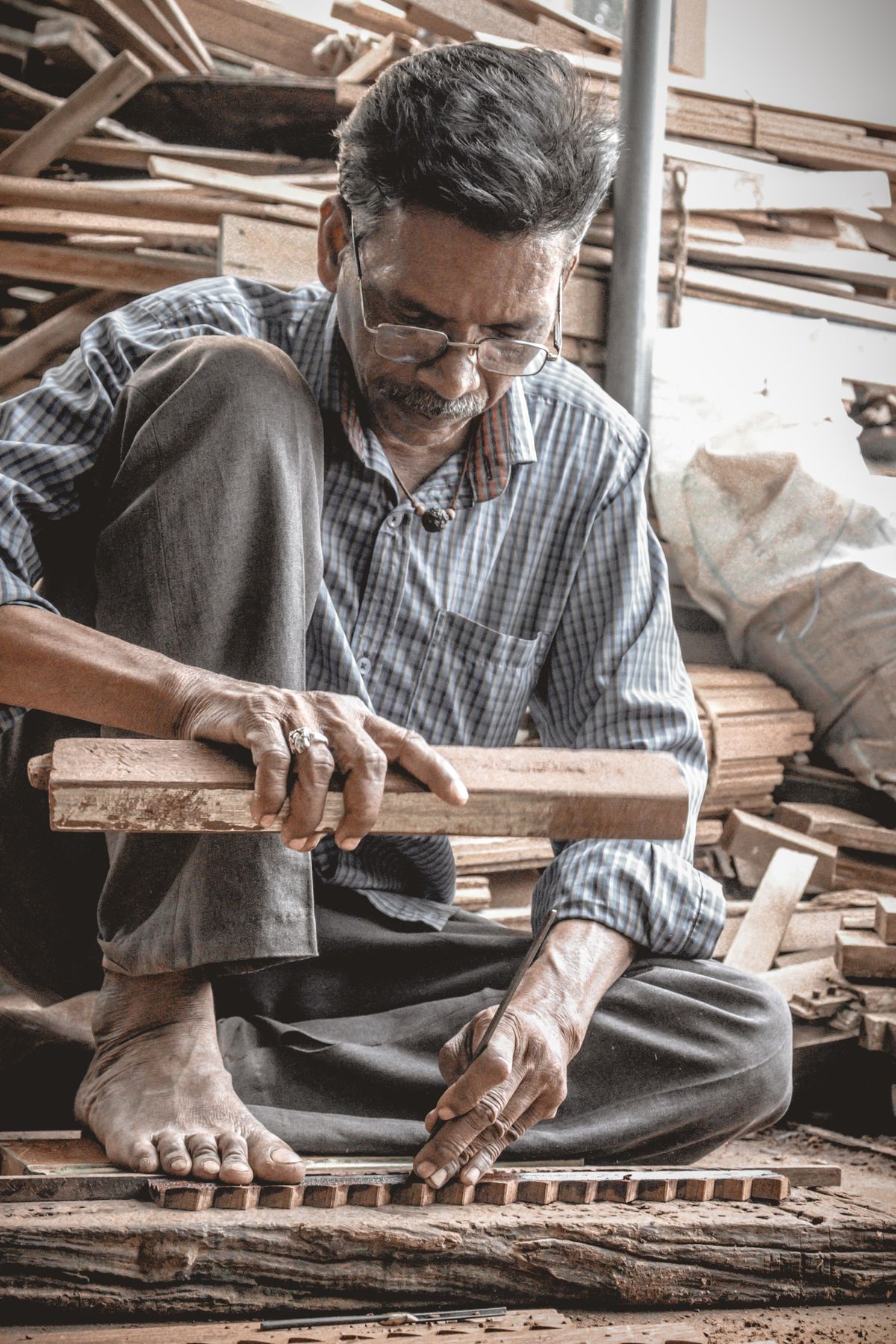 Hands at work planing a length of timber in the workshop